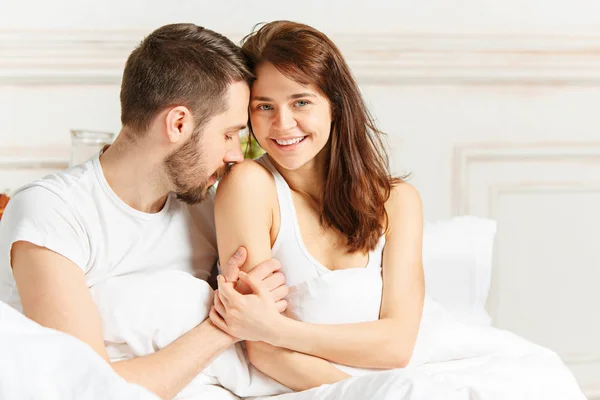 Jovem adulto casal heterossexual deitado na cama no quarto — Fotografia de Stock