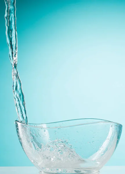 Les éclaboussures d'eau dans un bol en verre sur fond blanc — Photo