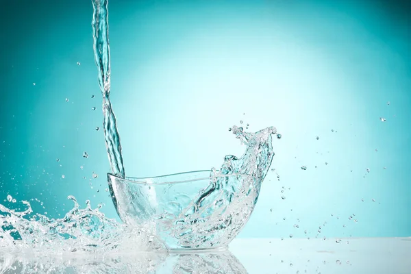 Woda rozpryskująca się szklana miska na białym tle — Zdjęcie stockowe
