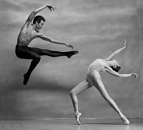 Pareja de bailarines de ballet posando sobre fondo gris — Foto de Stock