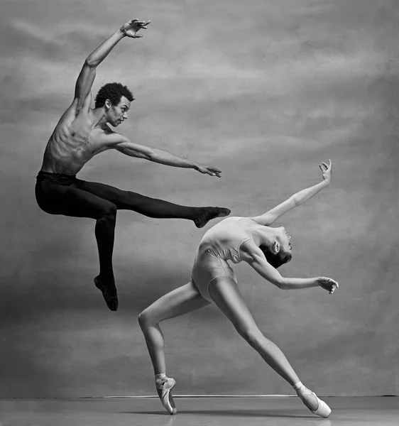 Pareja de bailarines de ballet posando sobre fondo gris — Foto de Stock