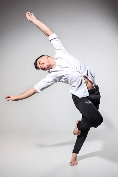 O jovem dançando em cinza — Fotografia de Stock