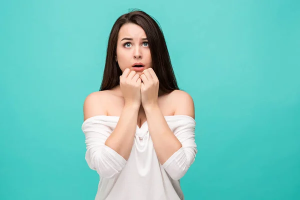 Frustrierte junge Frau posiert auf blauem Grund — Stockfoto
