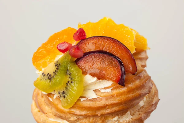 Fechar o bolo com frutas frescas no fundo cinza . — Fotografia de Stock