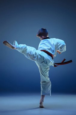 Genç çocuk eğitim karate mavi zemin üzerine