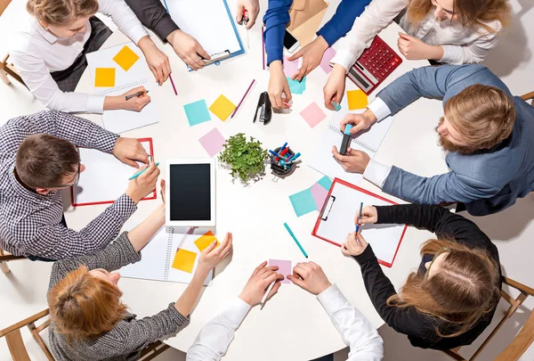 Equipo sentado detrás del escritorio, revisando informes, hablando. Vista superior — Foto de Stock