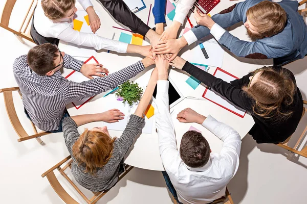 Team sitting behind desk, checking reports, talking. Top View — Stock Photo, Image