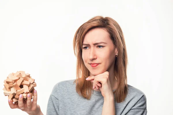 Atractiva mujer de negocios de 24 años que mira confundida con rompecabezas de madera . — Foto de Stock