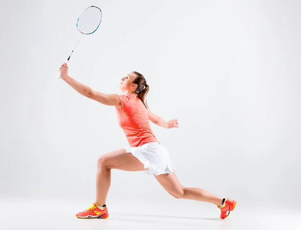 Jovem mulher jogando badminton sobre fundo branco — Fotografia de Stock
