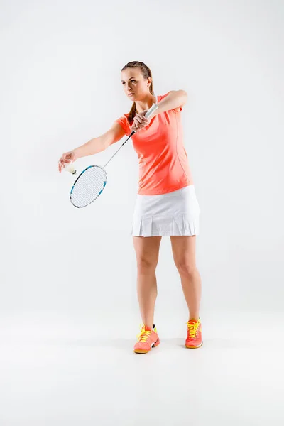 Mujer joven jugando bádminton sobre fondo blanco — Foto de Stock