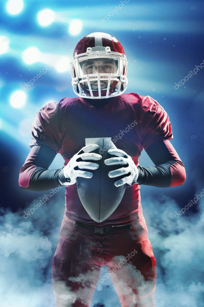 American football player posing with ball on stadium background — Stock
