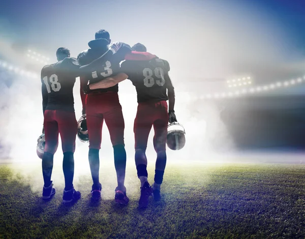 Los tres jugadores de fútbol americano en el fondo del estadio — Foto de Stock