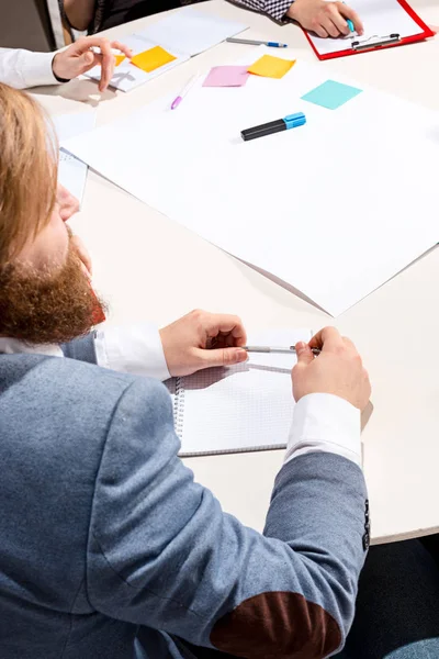 El hombre sentado detrás del escritorio, revisando informes, hablando . — Foto de Stock