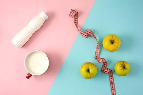 La manzana verde y la botella de yogur con cinta métrica — Foto de Stock