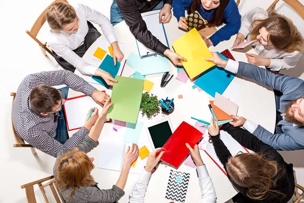 Equipo sentado detrás del escritorio, revisando informes, hablando. Vista superior — Foto de Stock