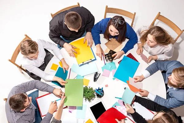 Team sitting behind desk, checking reports, talking. Top View — Stock Photo, Image