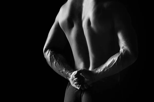 Bakifrån torsoen av attraktiva manliga kroppen builder på svart bakgrund. — Stockfoto