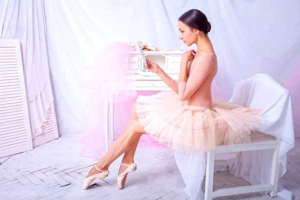 Професійна балетна танцівниця дивиться у дзеркало на рожевому — стокове фото