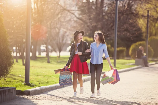 Две девушки прогуливаются с покупками по улицам города — стоковое фото