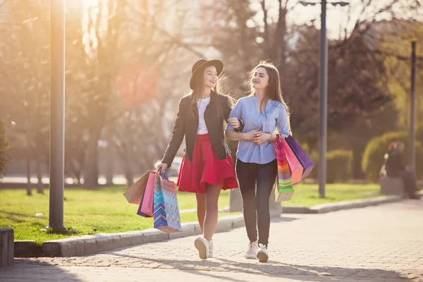 Две девушки прогуливаются с покупками по улицам города — стоковое фото