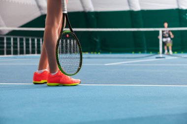 kapalı Tenis Kortu top ve raket ile genç kızın bacakları