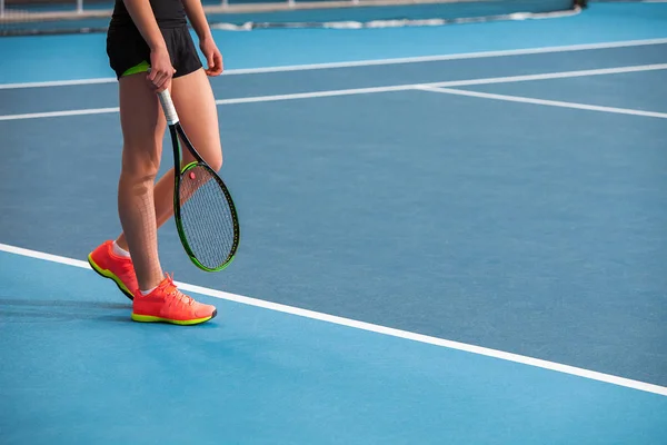 ボールとラケットの閉じたテニスコートの若い女の子の足 — ストック写真