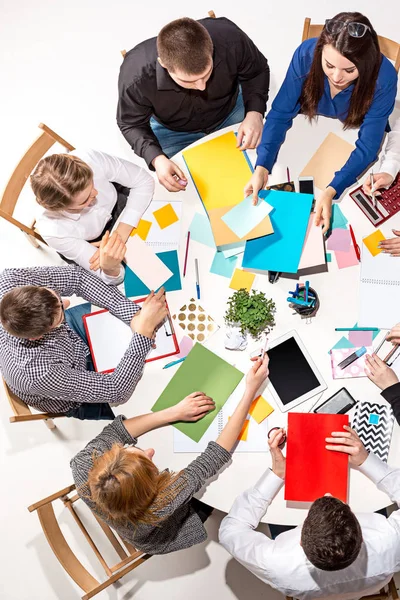 Team sitting behind desk, checking reports, talking. Top View — Stock Photo, Image