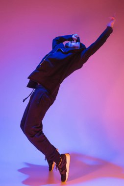Renkli arka plan üzerinde bir hip hop erkek break dansçı silüeti