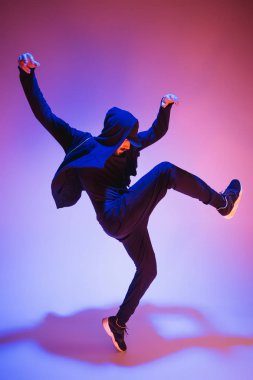 Renkli arka plan üzerinde bir hip hop erkek break dansçı silüeti