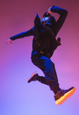 Renkli arka plan üzerinde bir hip hop erkek break dansçı silüeti