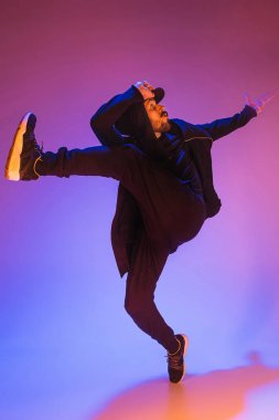 Renkli arka plan üzerinde bir hip hop erkek break dansçı silüeti
