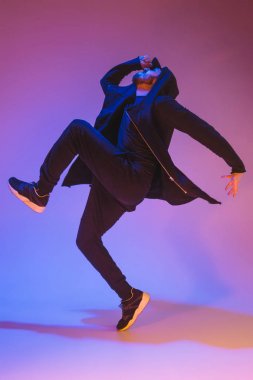 Renkli arka plan üzerinde bir hip hop erkek break dansçı silüeti