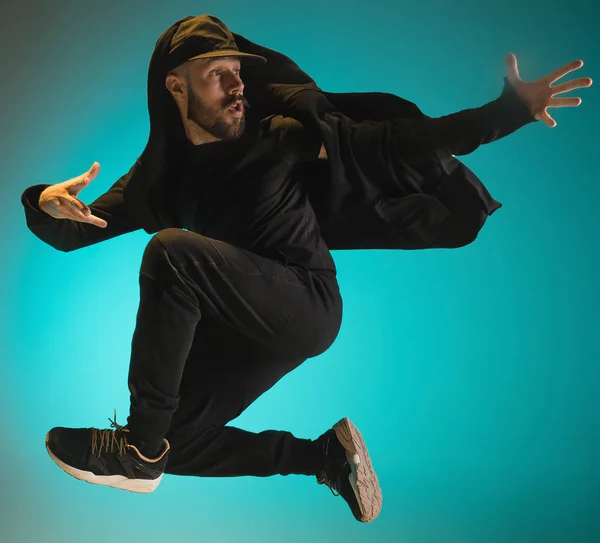A silhueta de um hip hop dançarino break masculino dançando em fundo colorido — Fotografia de Stock