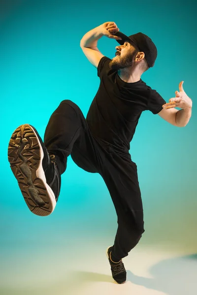 La silhouette d'un hip hop masculin break dancer dansant sur fond coloré — Photo