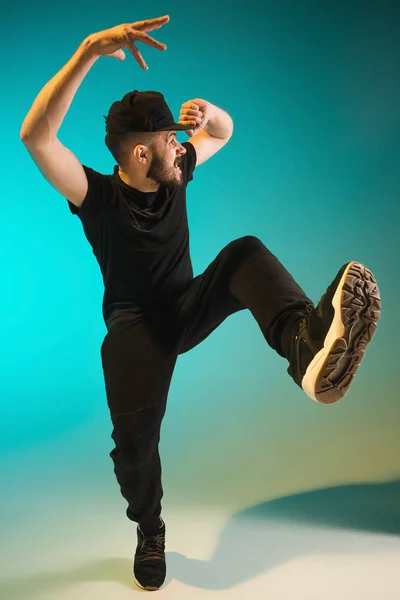 A silhueta de um hip hop dançarino break masculino dançando em fundo colorido — Fotografia de Stock