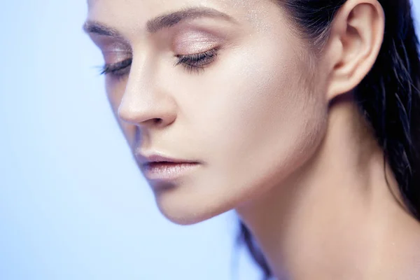 Mooie vrouw gezicht portret close-up op blauw — Stockfoto