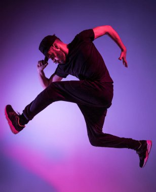 Renkli arka plan üzerinde bir hip hop erkek break dansçı silüeti