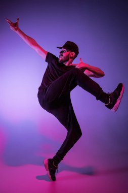 Renkli arka plan üzerinde bir hip hop erkek break dansçı silüeti
