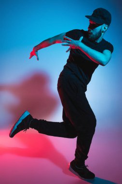Renkli arka plan üzerinde bir hip hop erkek break dansçı silüeti