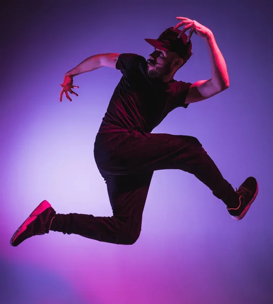 La silhouette d'un hip hop masculin break dancer dansant sur fond coloré — Photo