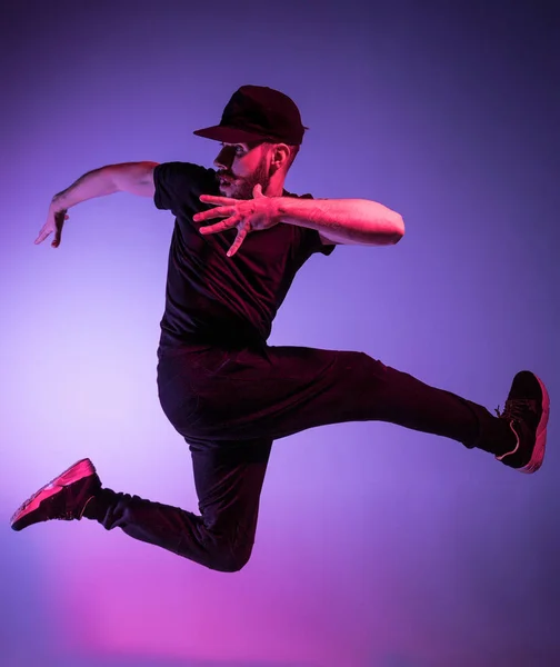 La silueta de un bailarín de break masculino de hip hop bailando sobre un fondo colorido — Foto de Stock