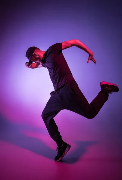 A silhueta de um hip hop dançarino break masculino dançando em fundo colorido — Fotografia de Stock