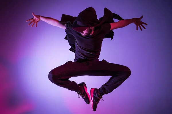 La silueta de un bailarín de break masculino de hip hop bailando sobre un fondo colorido —  Fotos de Stock