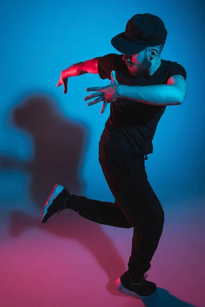 La silueta de un bailarín de break masculino de hip hop bailando sobre un fondo colorido — Foto de Stock