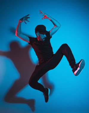 Renkli arka plan üzerinde bir hip hop erkek break dansçı silüeti
