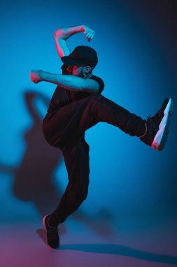 Renkli arka plan üzerinde bir hip hop erkek break dansçı silüeti