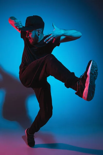 La silueta de un bailarín de break masculino de hip hop bailando sobre un fondo colorido —  Fotos de Stock