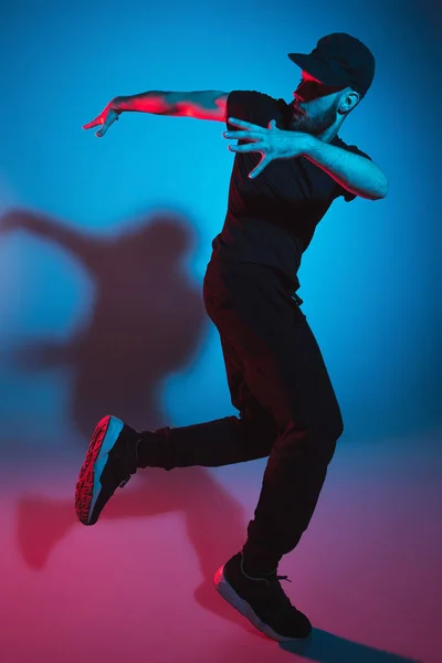 La silueta de un bailarín de break masculino de hip hop bailando sobre un fondo colorido —  Fotos de Stock