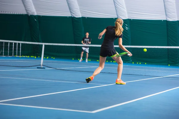 Het jonge meisje in een gesloten tennisbaan met bal — Stockfoto