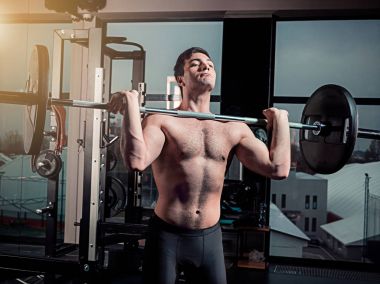 Süper portresi barbell ile spor salonunda egzersiz kas genç adam uygun